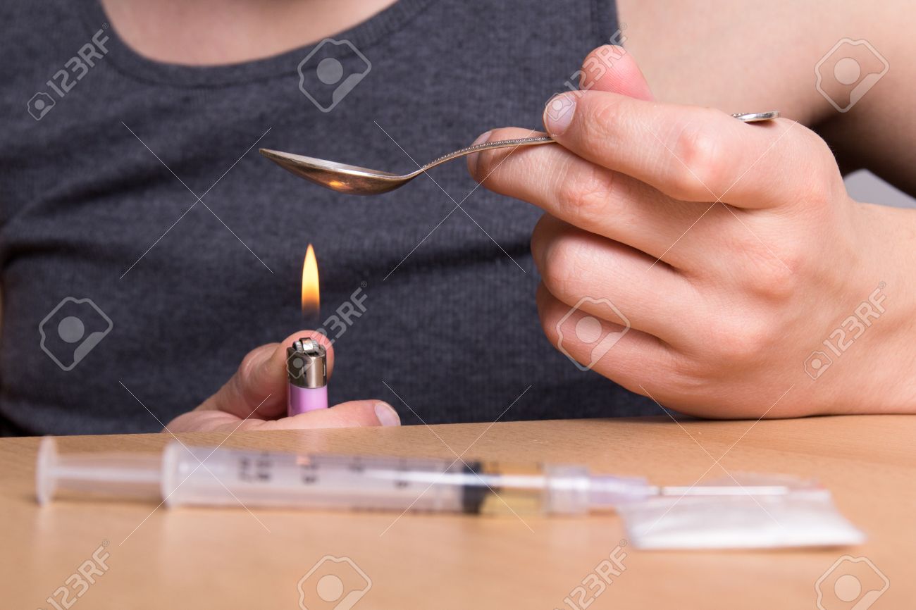 25221191-addict-heating-heroin-in-a-spoon-over-a-flame-Stock-Photo.jpg